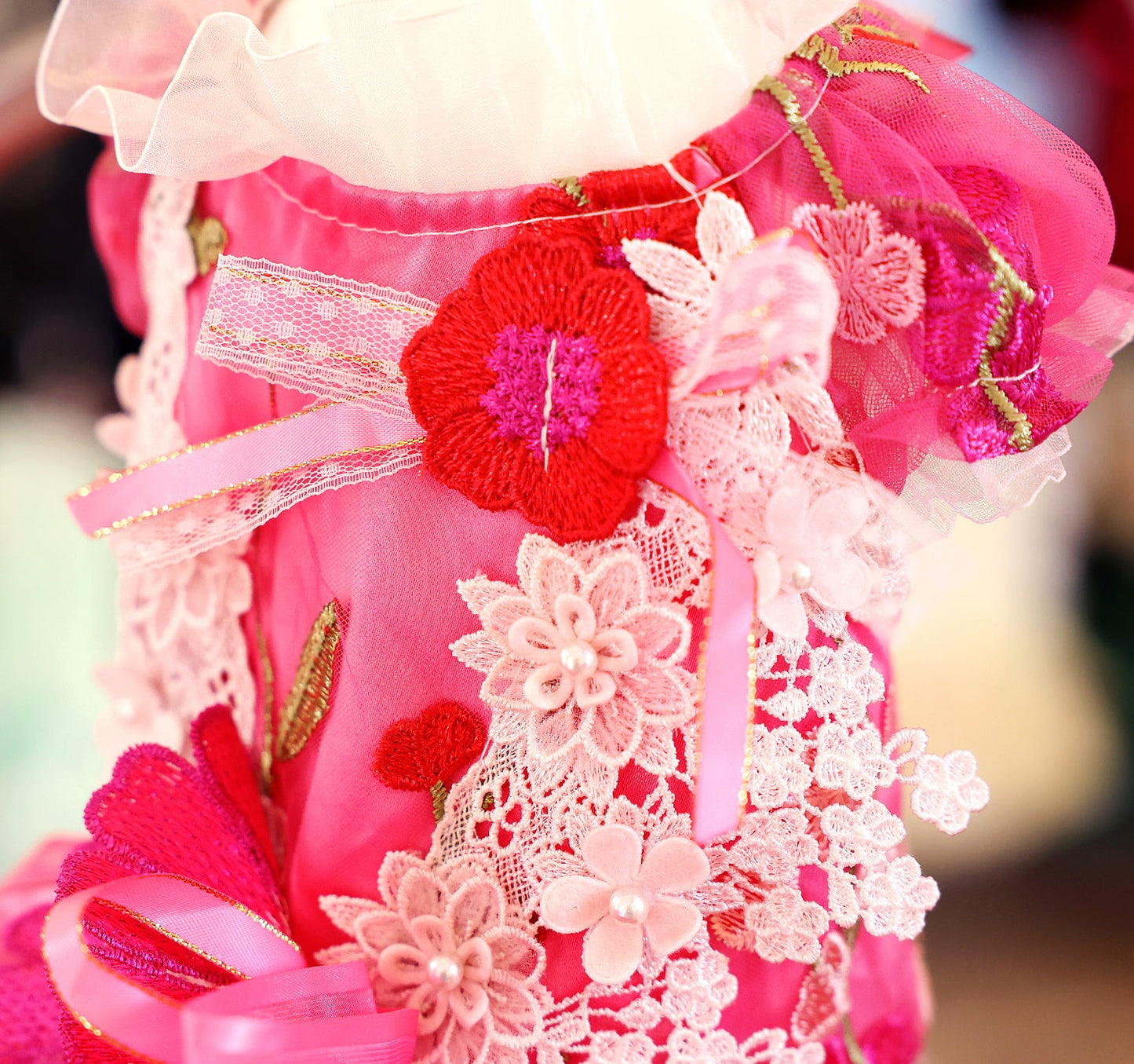 Close-up of a pink dress with floral and lace details