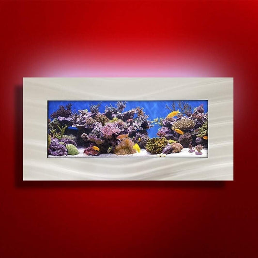 Framed aquarium display with colorful coral and fish on a red wall