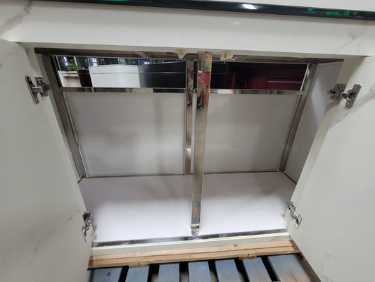 Stainless steel cabinet door with hinges on a white cabinet