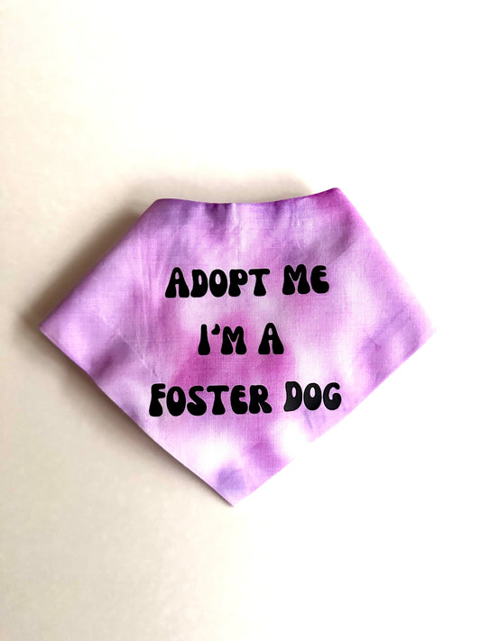 Purple tie-dye bandana with 'Adopt Me I'm a Foster Dog' text on a beige background