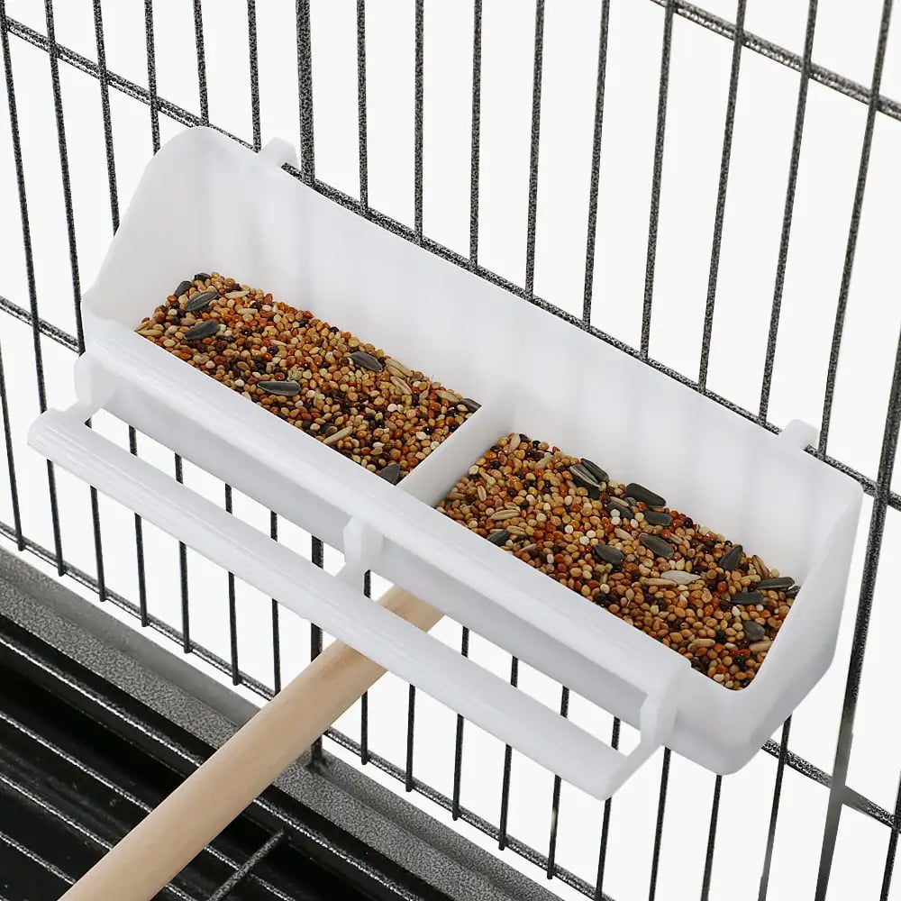 Bird feeder tray with seeds inside a cage