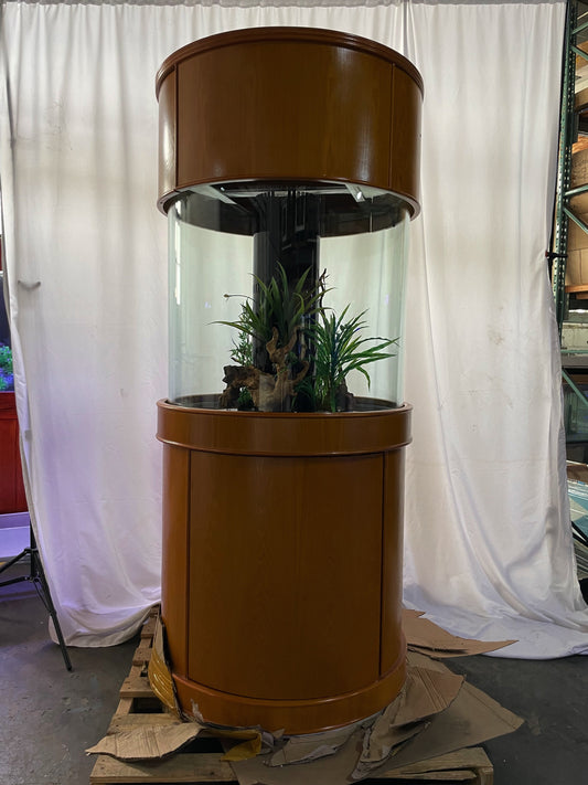 Brown cylindrical fish tank with plants on a white curtain background