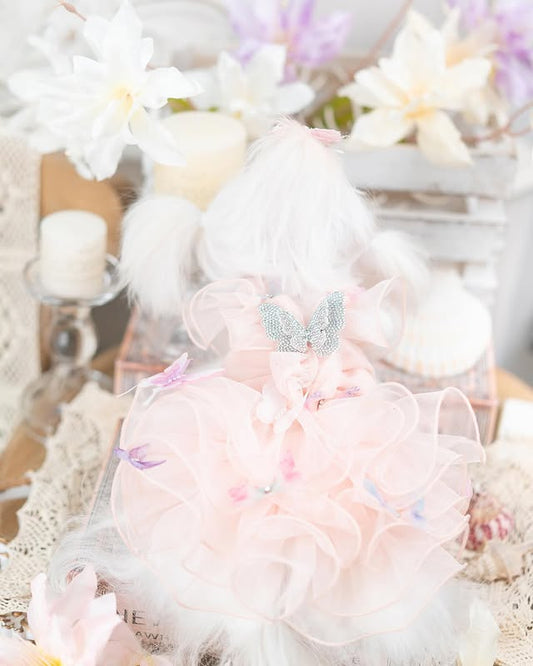 Pastel-colored plush toy with decorative elements on a soft, textured background