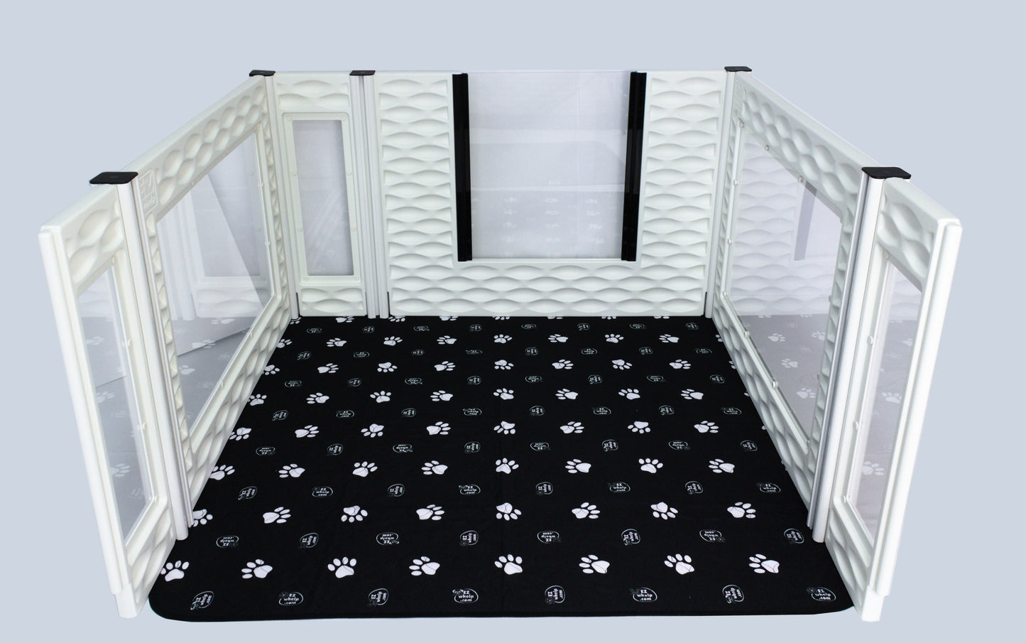 Pet playpen with a black mat featuring paw prints on a white background