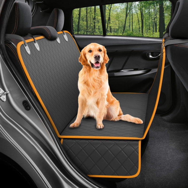 Dog sitting on a car seat cover with a forest view outside the car window.