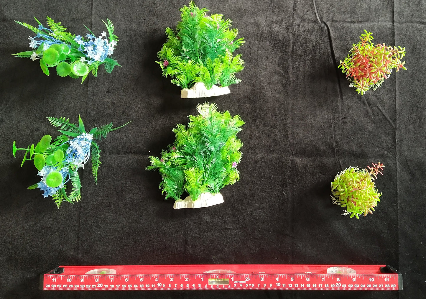 Set of artificial plants on a black background with a ruler at the bottom.