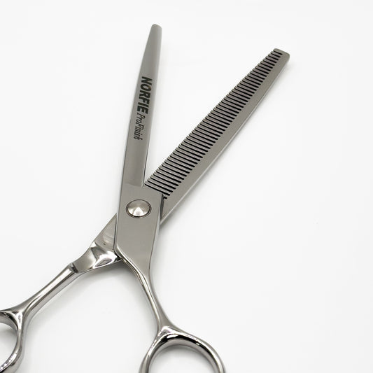 Hair cutting shears with a comb on a white background
