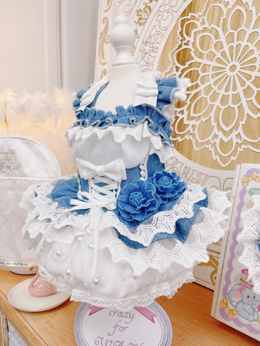 Decorative lamp with blue flowers and white lace on a wooden surface.