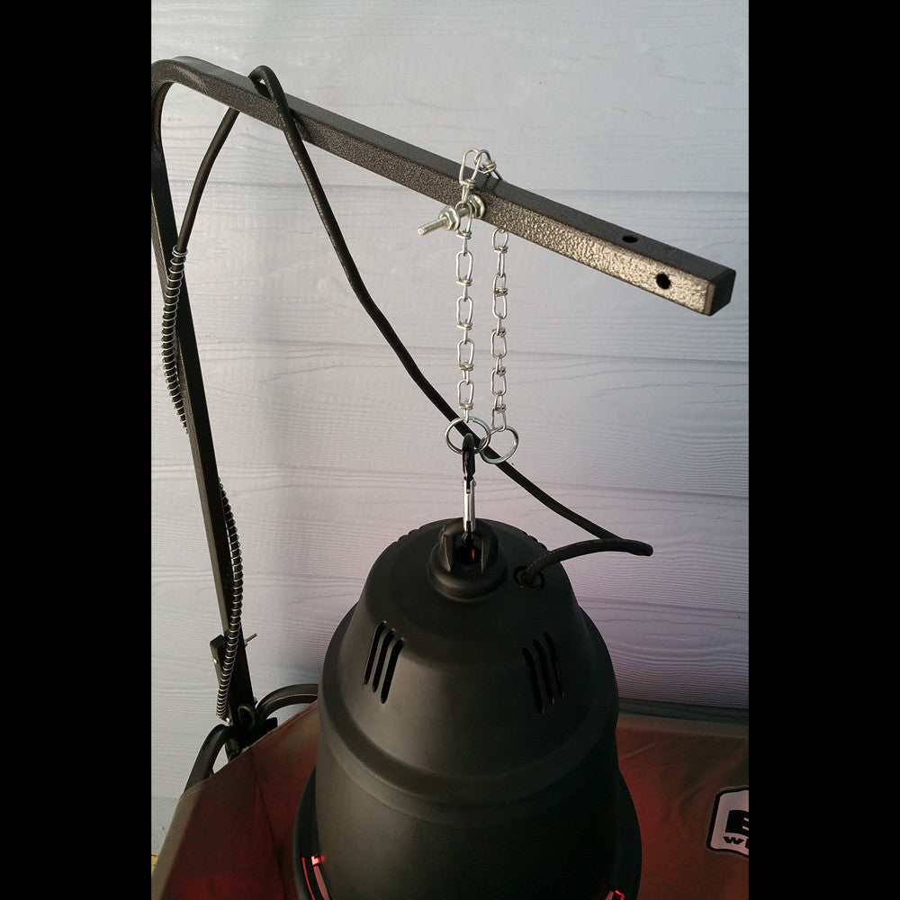 Black oil lamp with hanging chain against a light-colored wall