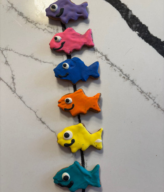 Colorful fish-shaped magnets on a marble surface
