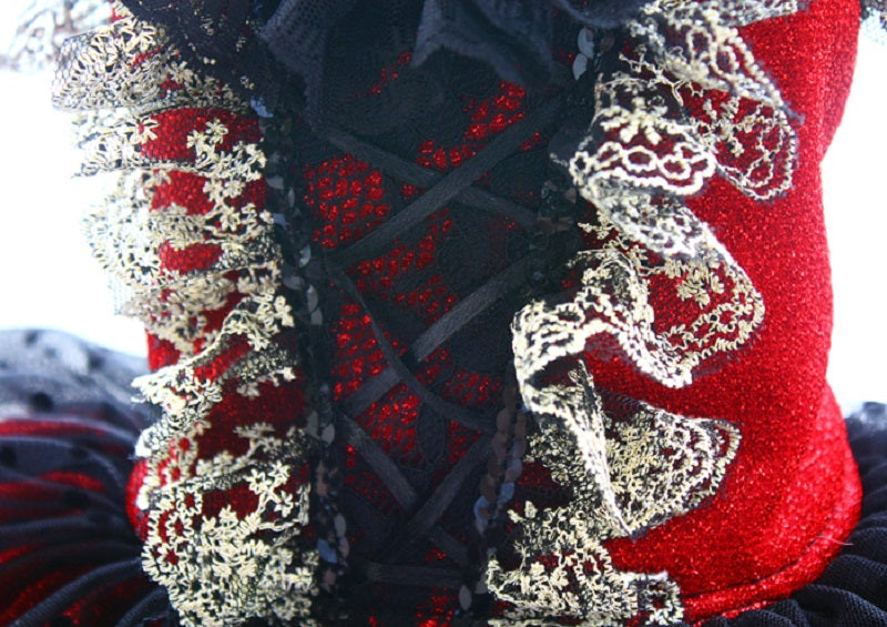 Close-up of a red fabric with white floral patterns, possibly part of a garment or decorative item.