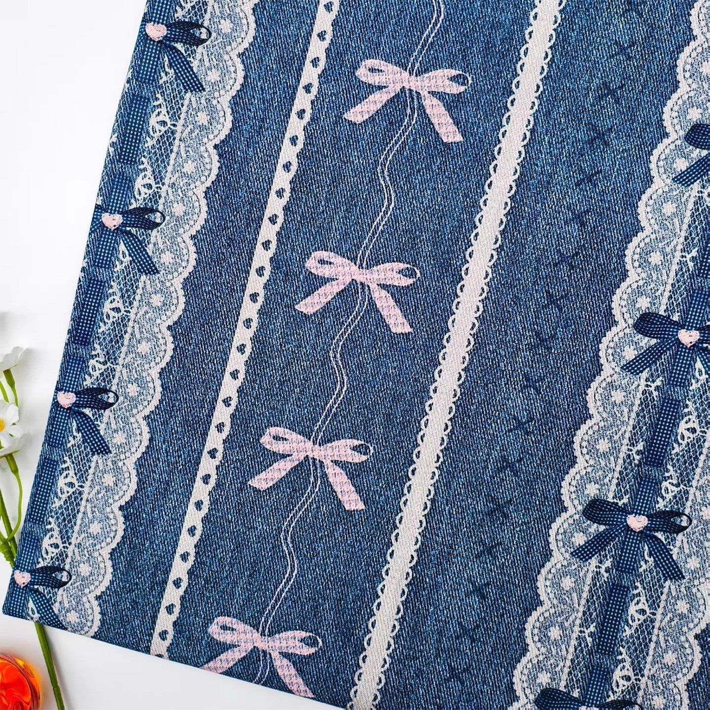 Blue fabric with lace and pink bows on a white background