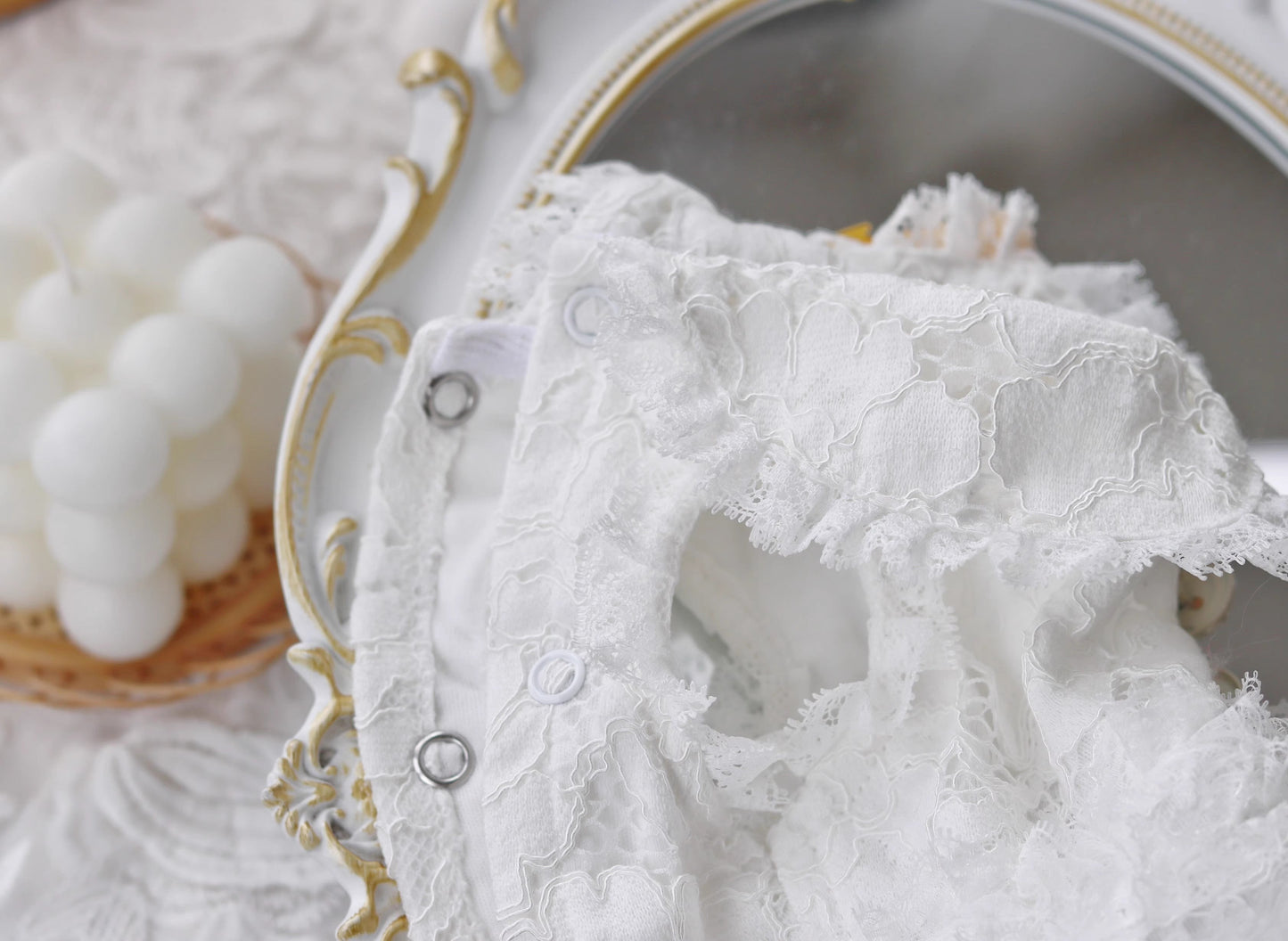 Close-up of a lace garment with a decorative plate in the background
