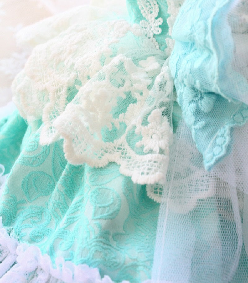 Close-up of mint green lace fabric with white lace details