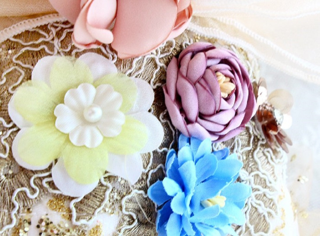 Colorful flower-shaped hair clips on a textured surface