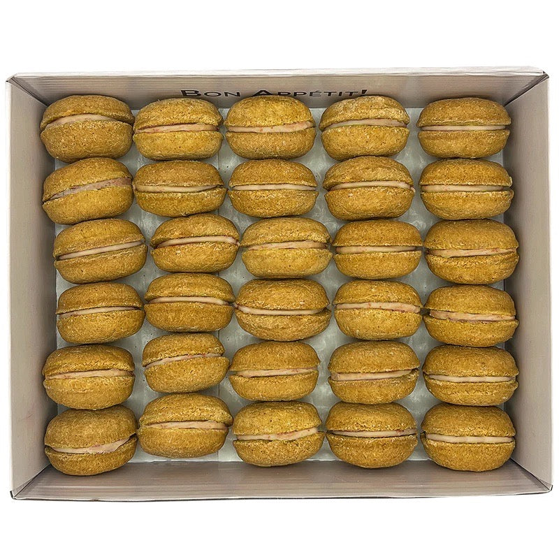 Box of pumpkin spice macarons with a visible brand name on a white background
