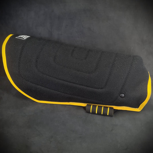 Black motorcycle seat cover with yellow trim on a dark background