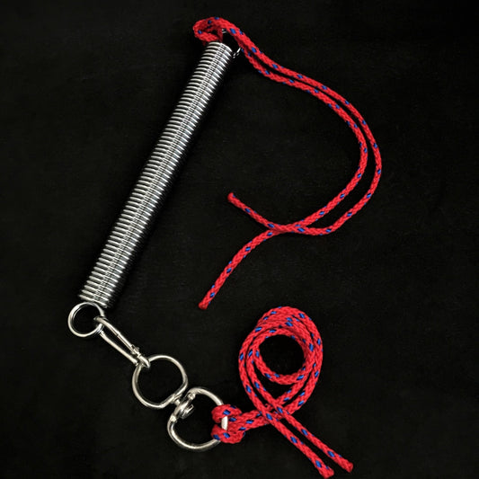 Metal spring with red rope on a black background