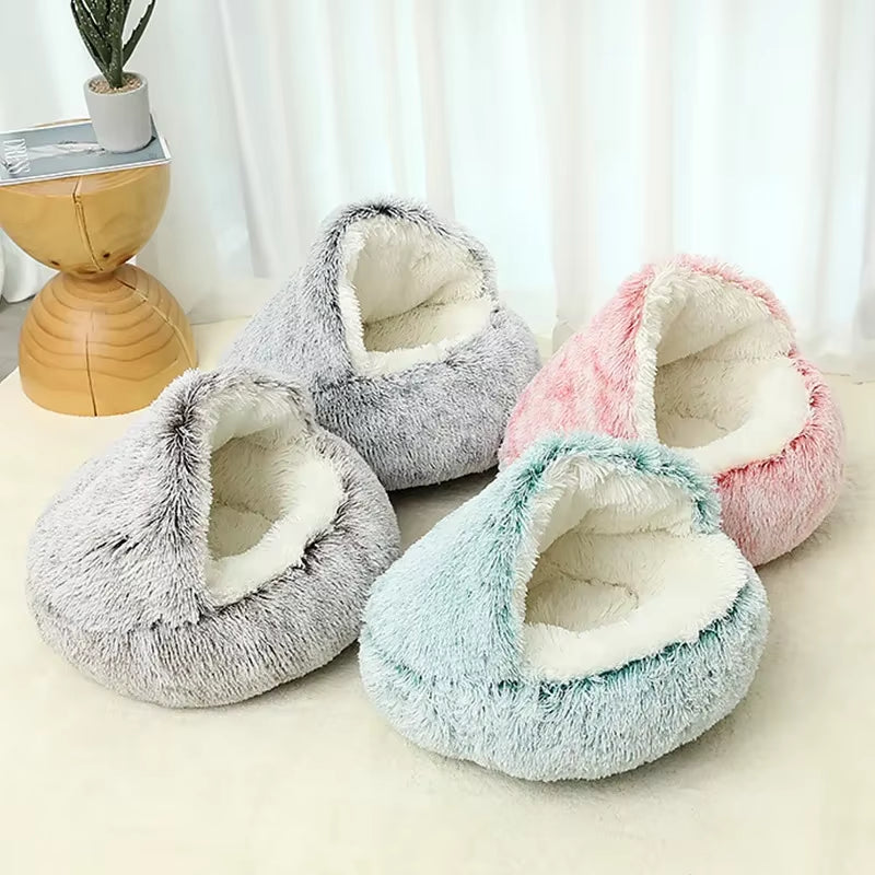Four fluffy pet beds for small cats and dogs in gray, pink, and blue on a light surface with a white curtain background.