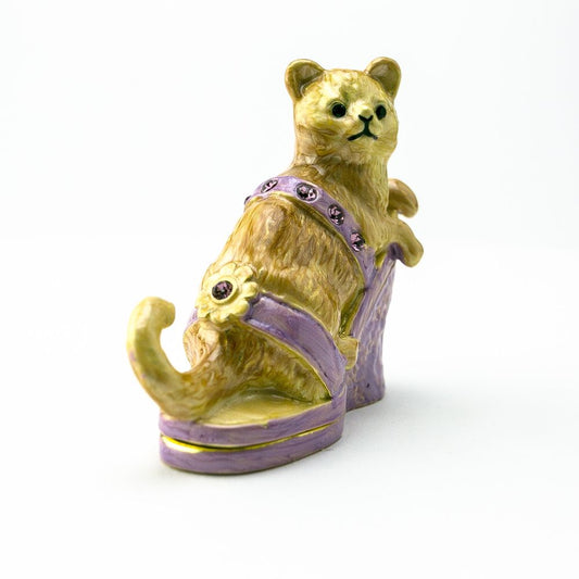 Cat figurine with a purple harness on a white background