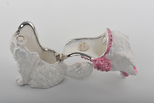 Silver dog-shaped jewelry holder with pink accents on a white background