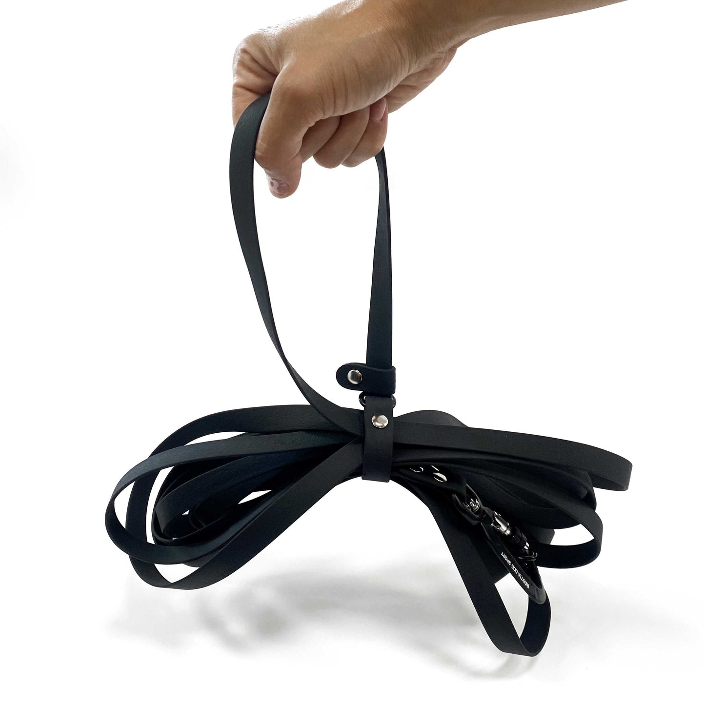 Black dog leash with a hand holding it on a white background