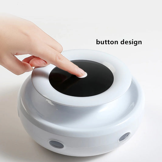 Hand pressing a button on a White Interactive Toy with a Black Center.