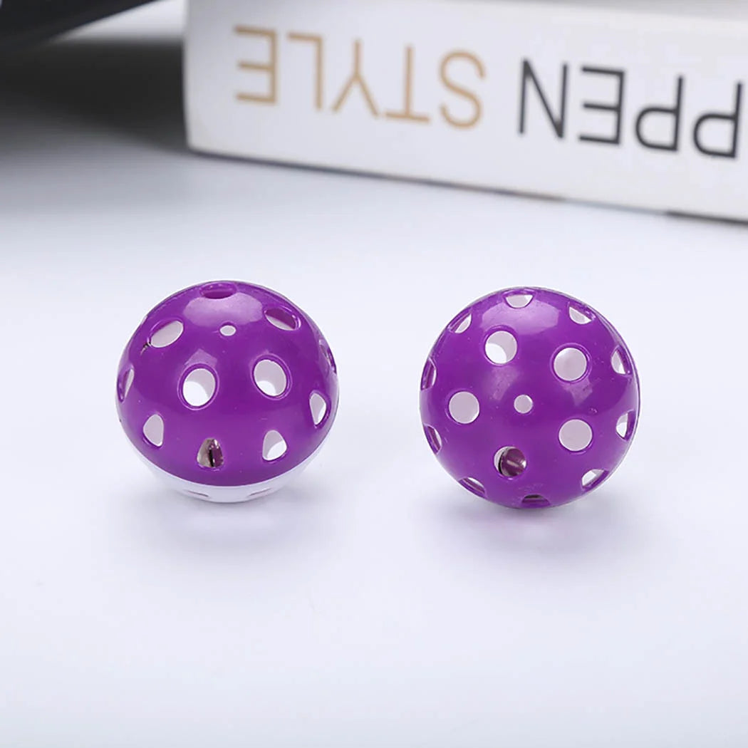Two Purple Cat Ball Toys on a white surface with a blurred background.