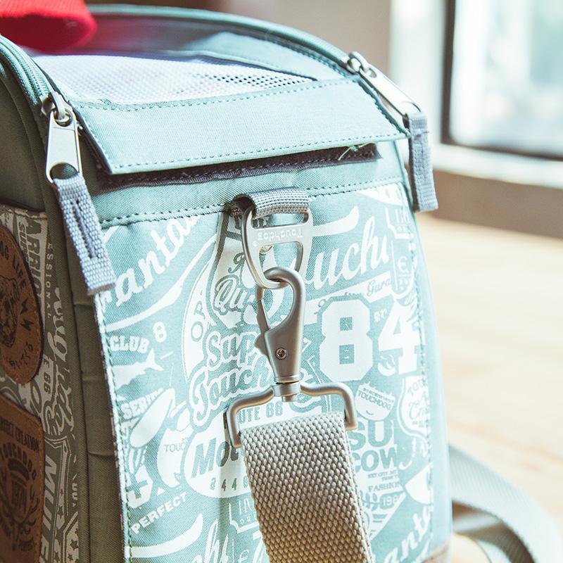 Light blue bag with text pattern and metal clasp on a blurred background