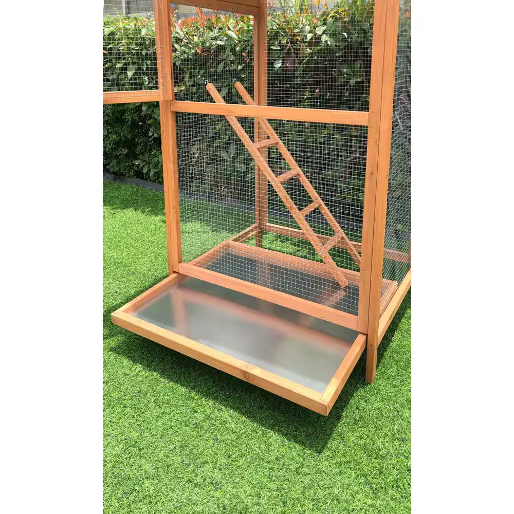 Wooden pet cage with a ramp on a grassy surface