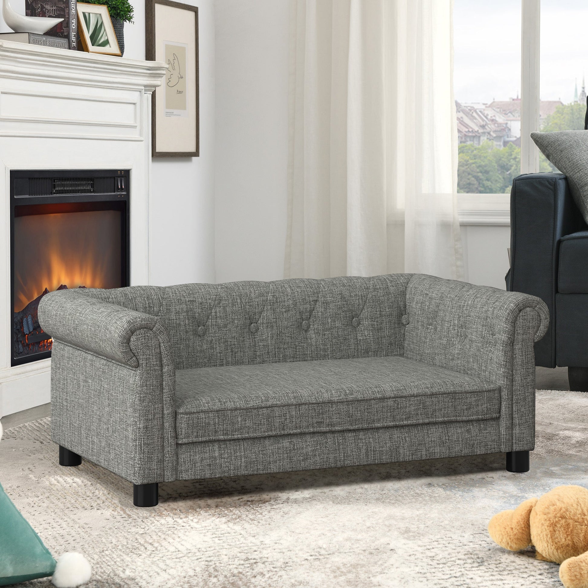 Gray sofa in a living room with a fireplace and window.
