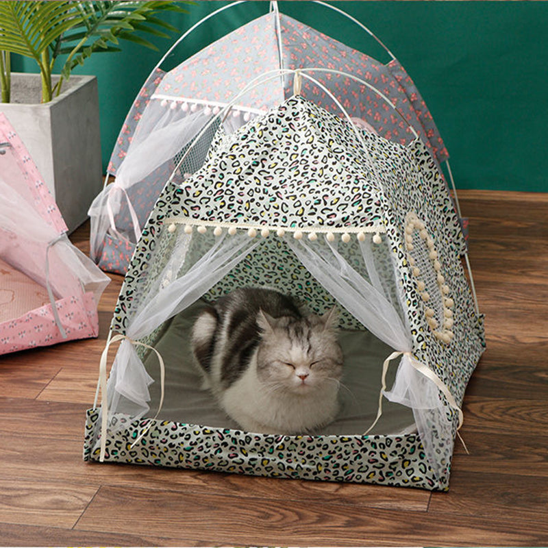 Cat lying inside a leopard print pet tent with a green background
