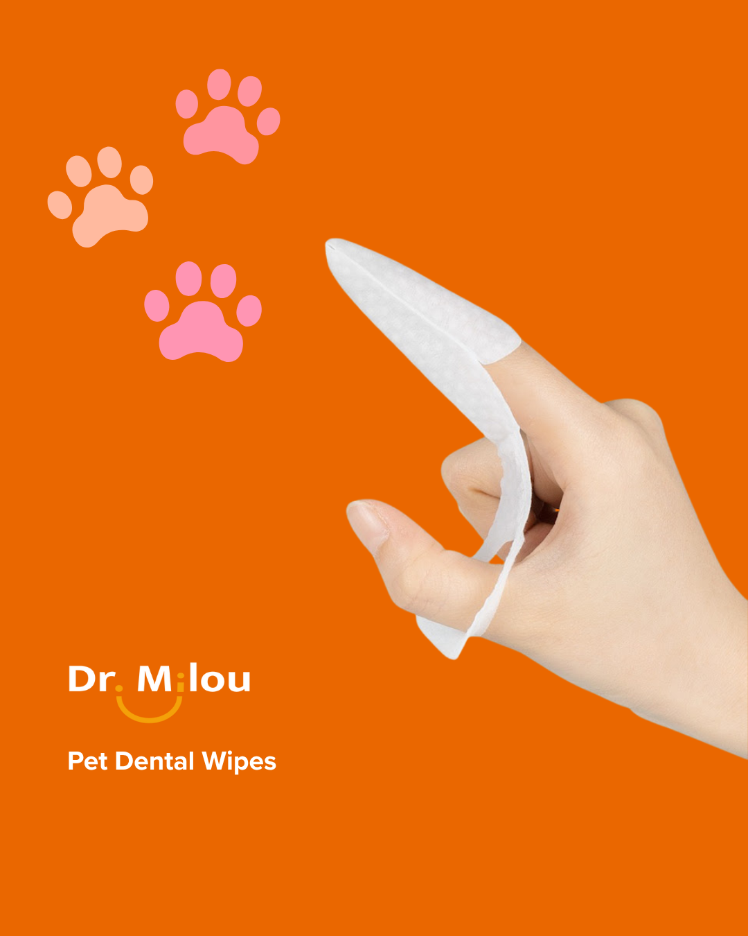 Hand holding a white pet dental wipe with pink paw prints on an orange background, featuring the brand 'Dr. Milou'.