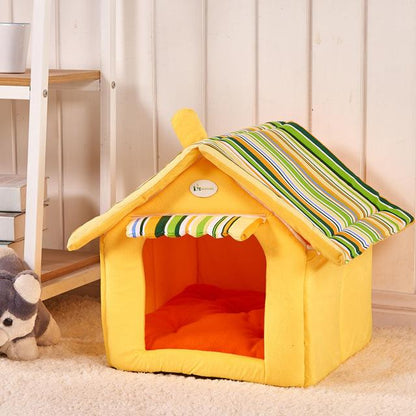 Yellow pet house with striped roof on a carpeted floor