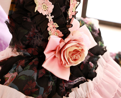 Close-up of a floral dress with pink roses and black lace details.