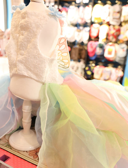 Mannequin wearing a colorful dress with a blurred background of other dresses.