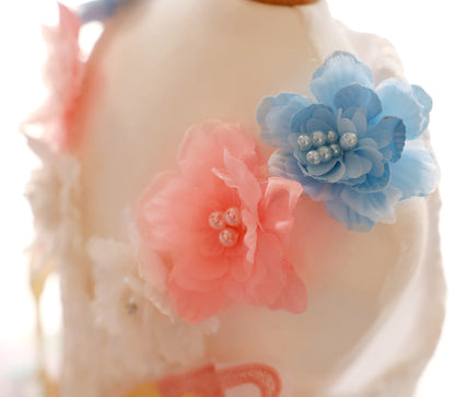 Decorative headband with pink and blue flowers on a white background