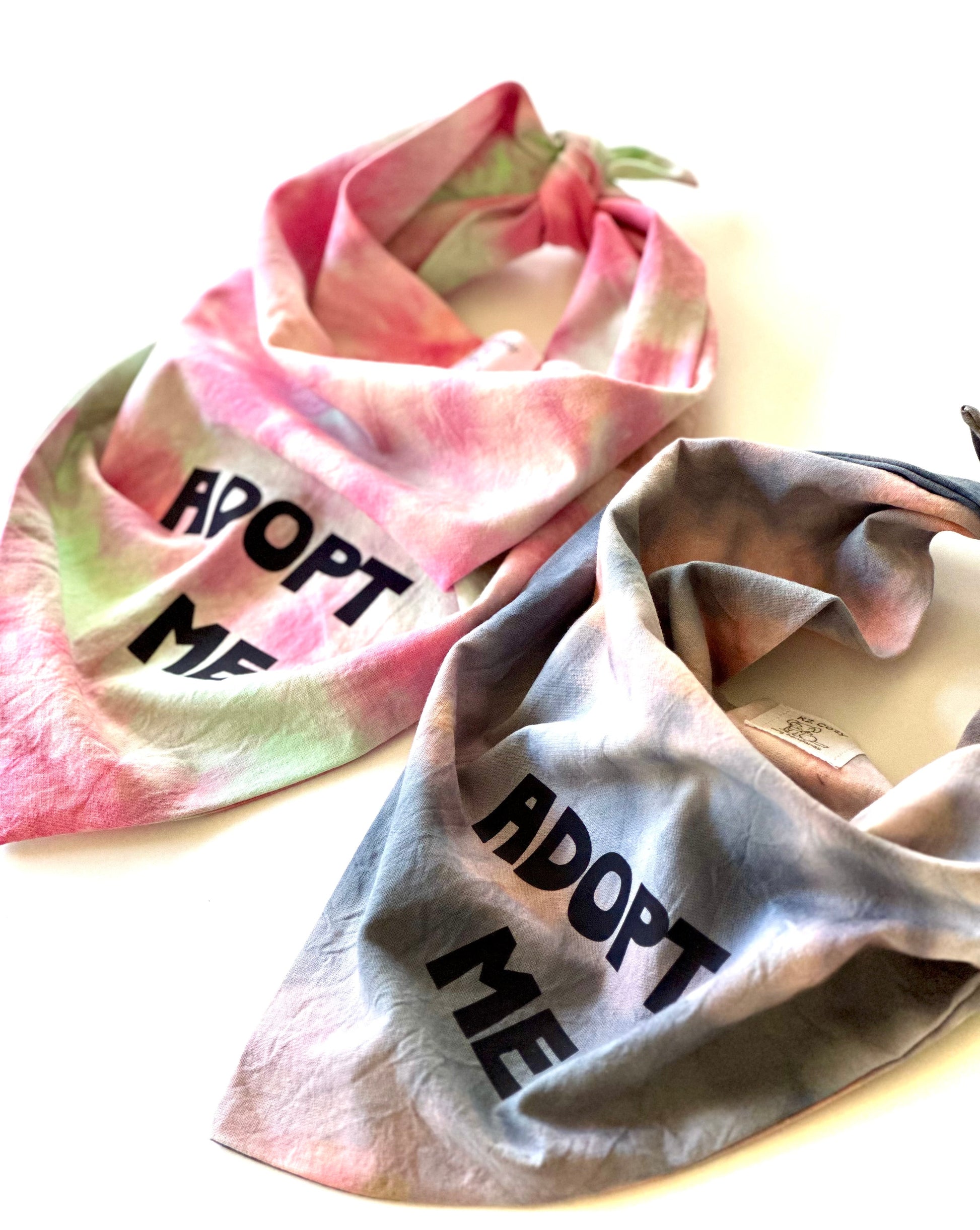 Two tie-dye bandanas with 'ADOPT ME' text on a white background