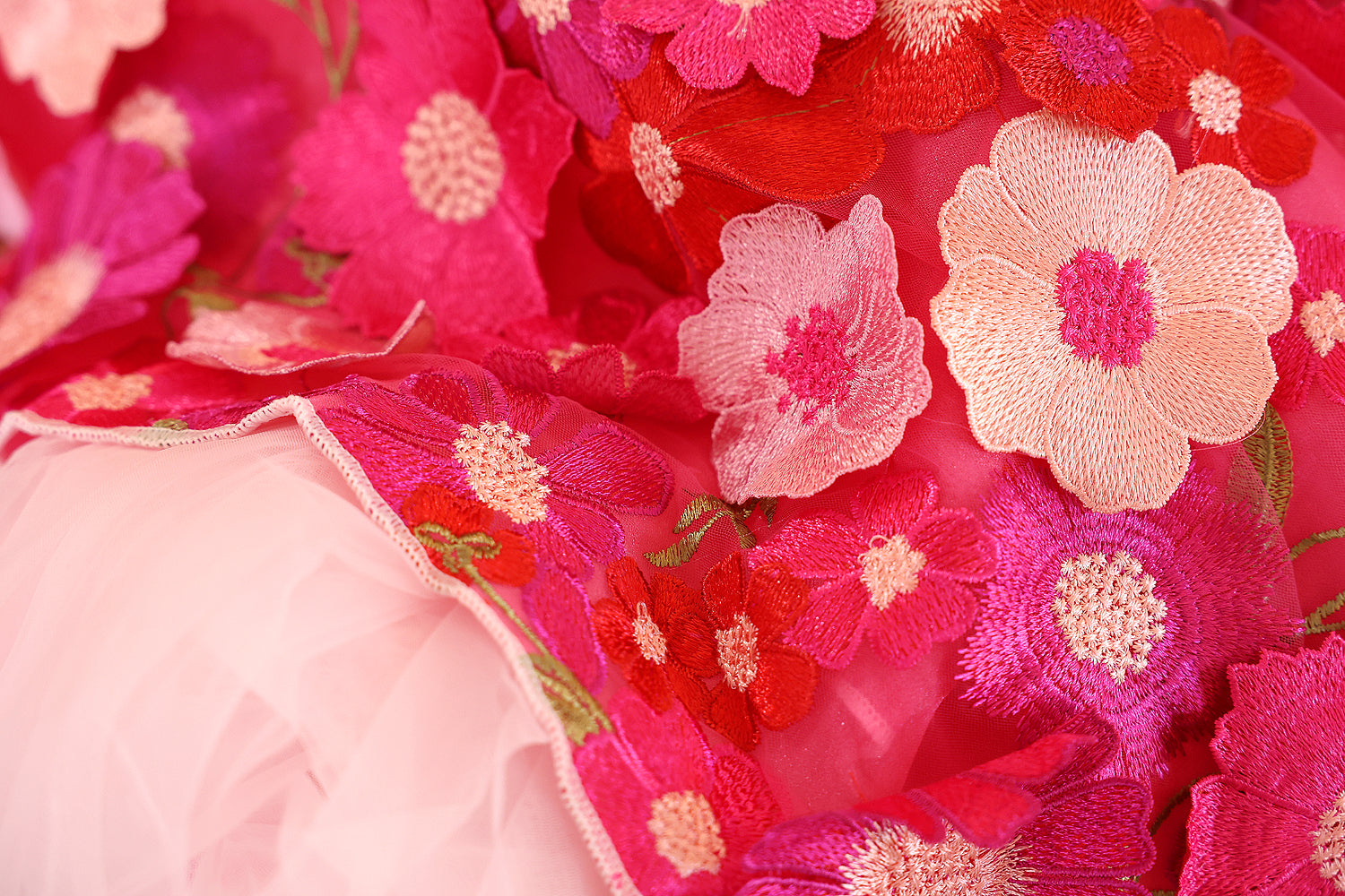 Close-up of pink and red floral embroidery on fabric