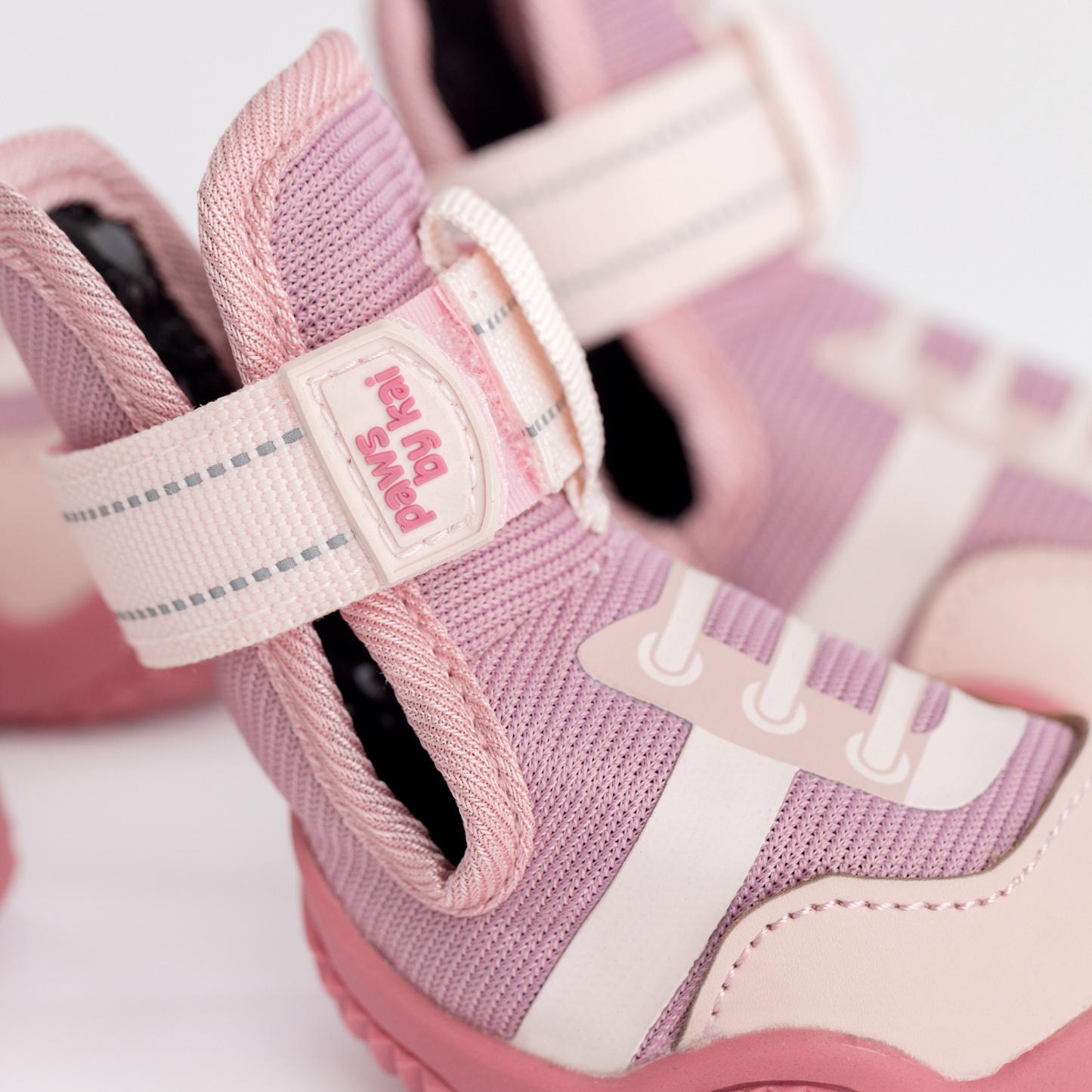 Close-up of pink children's shoes with a visible brand name on a white background