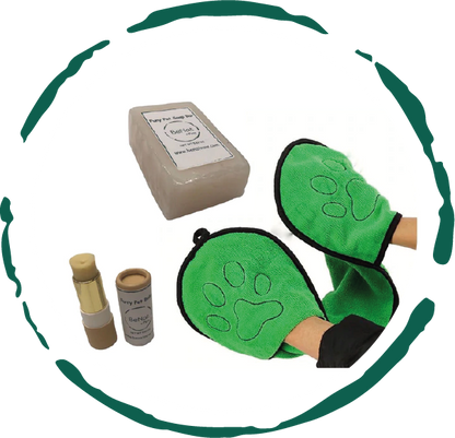 Green pet grooming mitts with a box and bottles on a white background