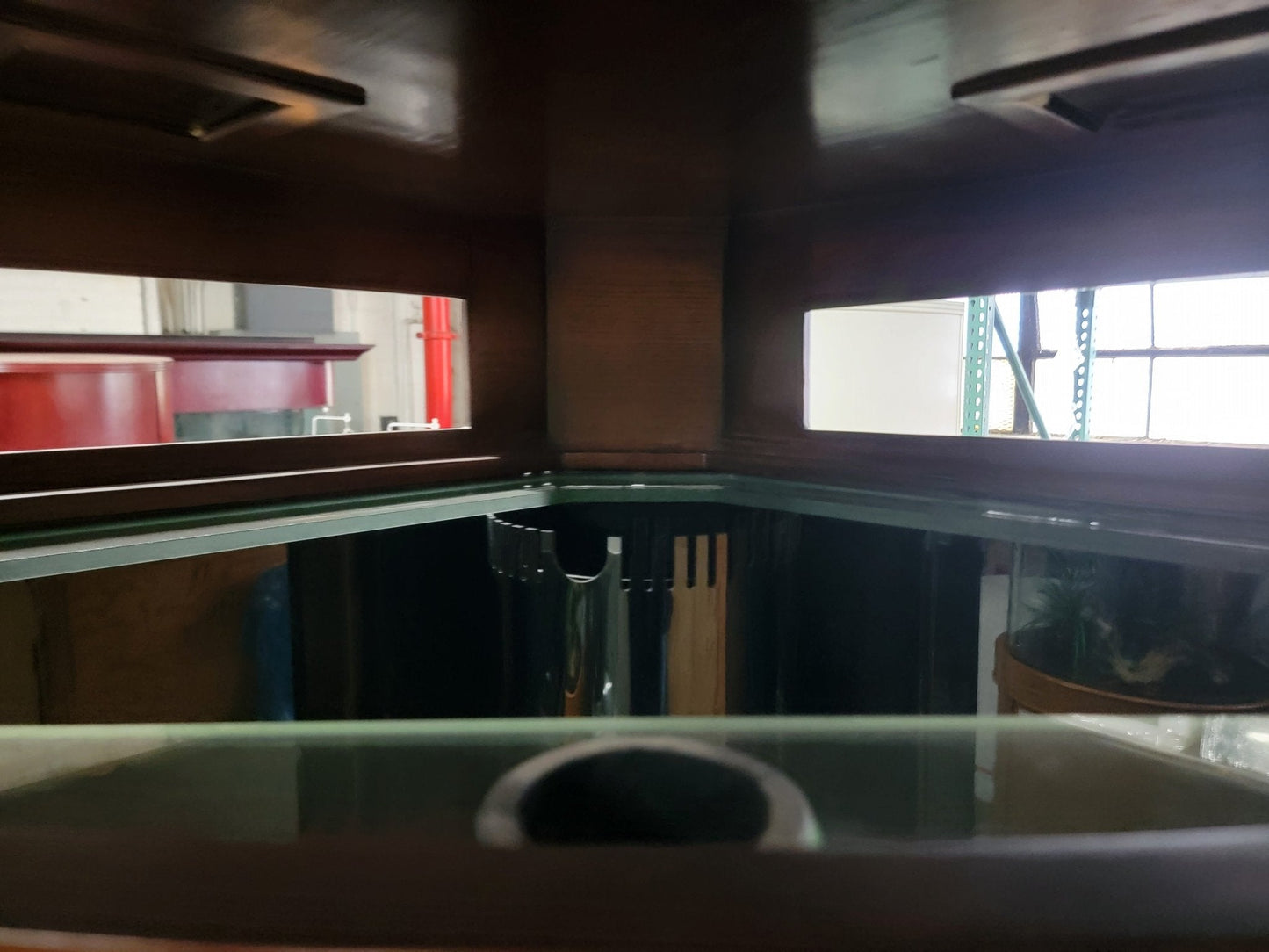Dark interior of a vehicle with a window and ceiling lights.