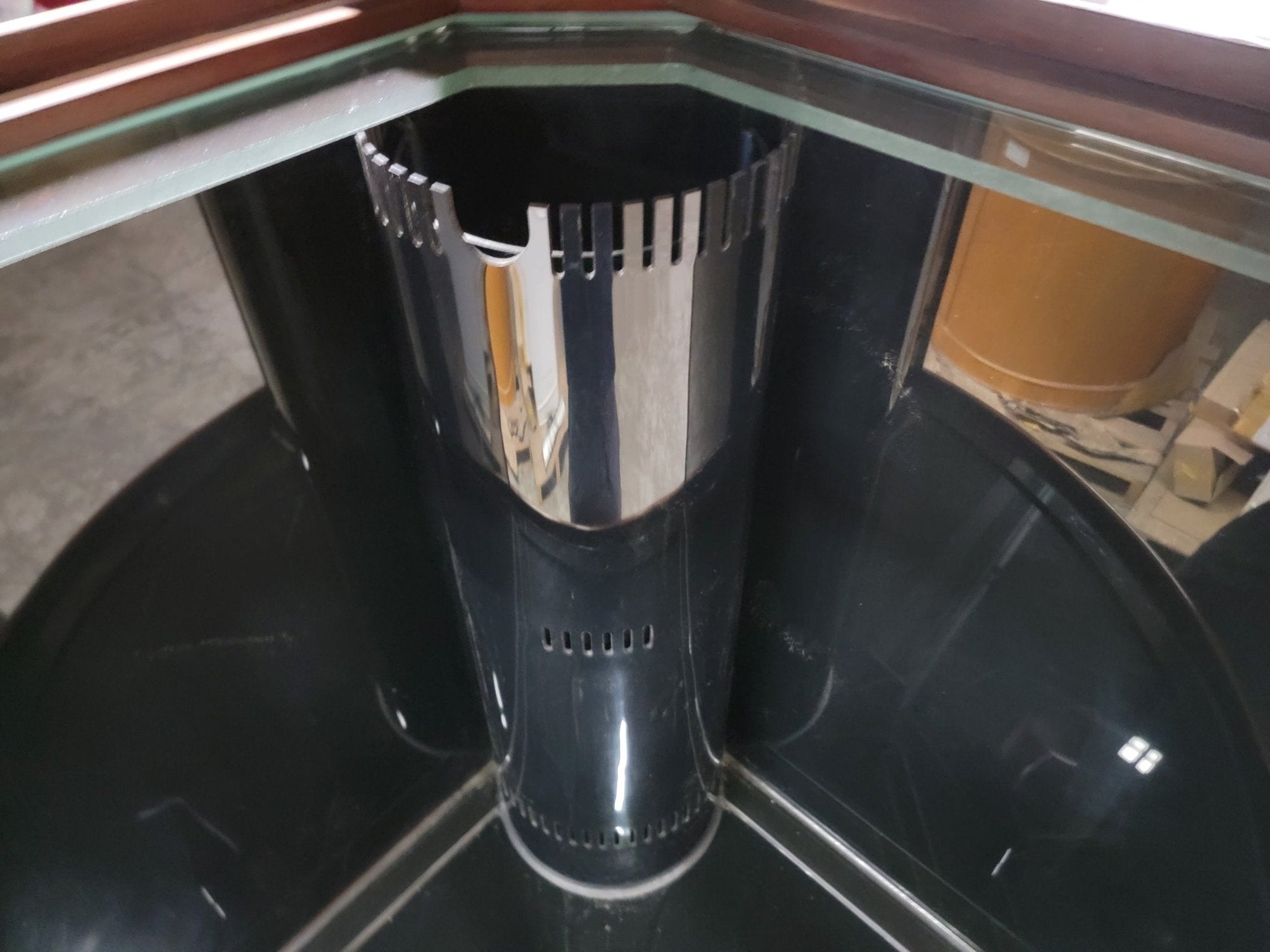 Black and silver cylindrical object inside a glass enclosure