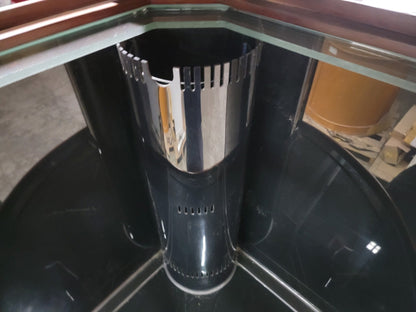 Black and silver cylindrical object inside a glass enclosure