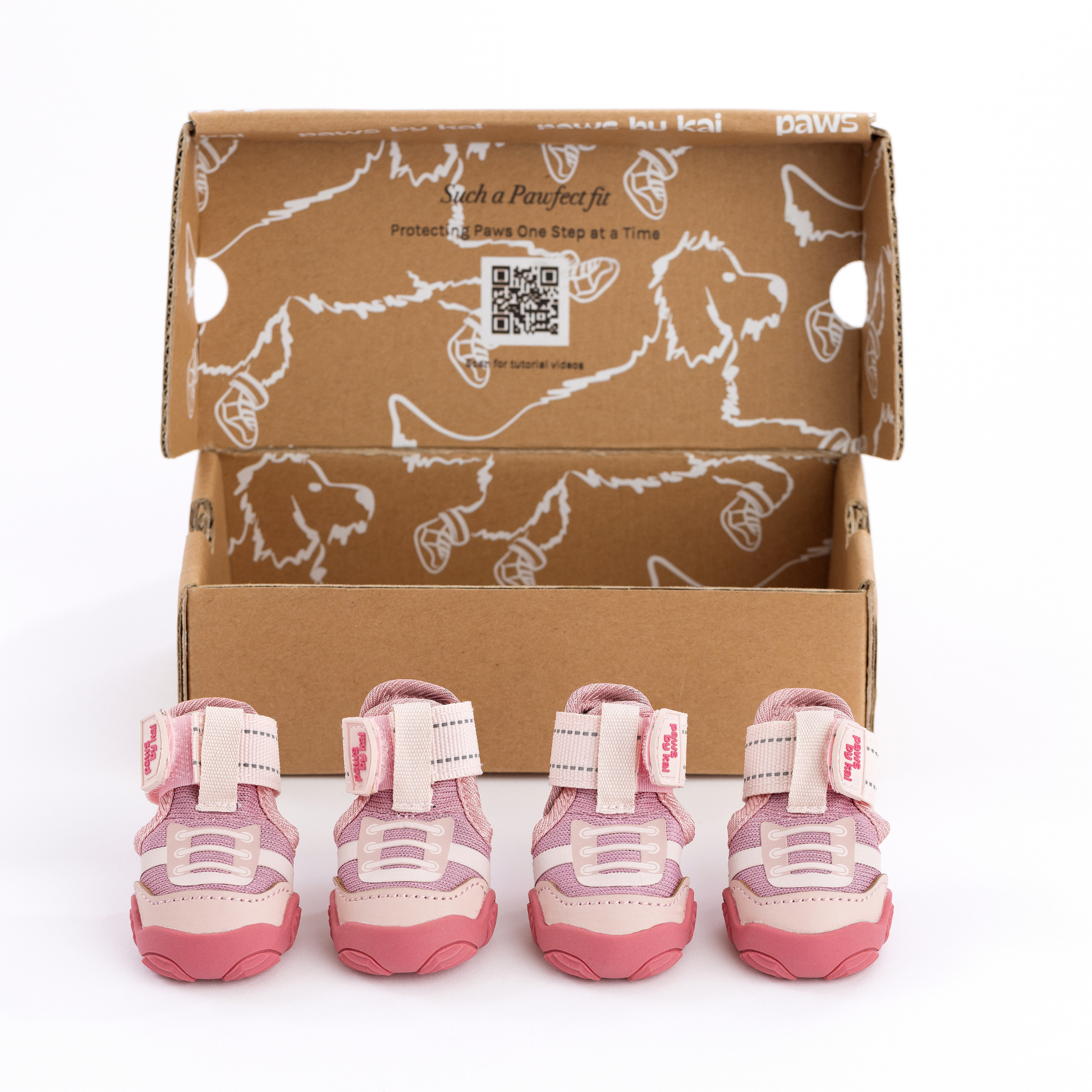 Set of pink dog boots with a cardboard box featuring paw prints on a white background