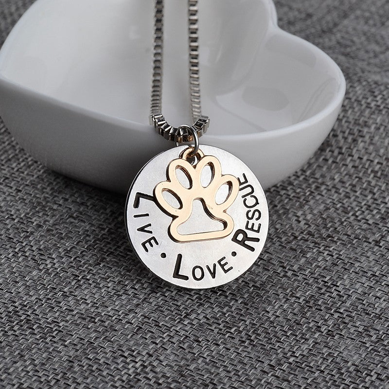 Necklace with a pendant featuring a paw print and 'Live Love Rescue' text on a textured surface.
