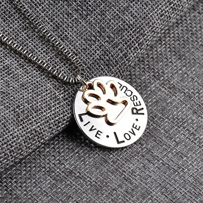Necklace with a pendant featuring a handprint and engraved text on a textured gray background