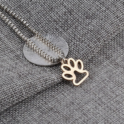 Necklace with a gold paw charm on a textured gray fabric background