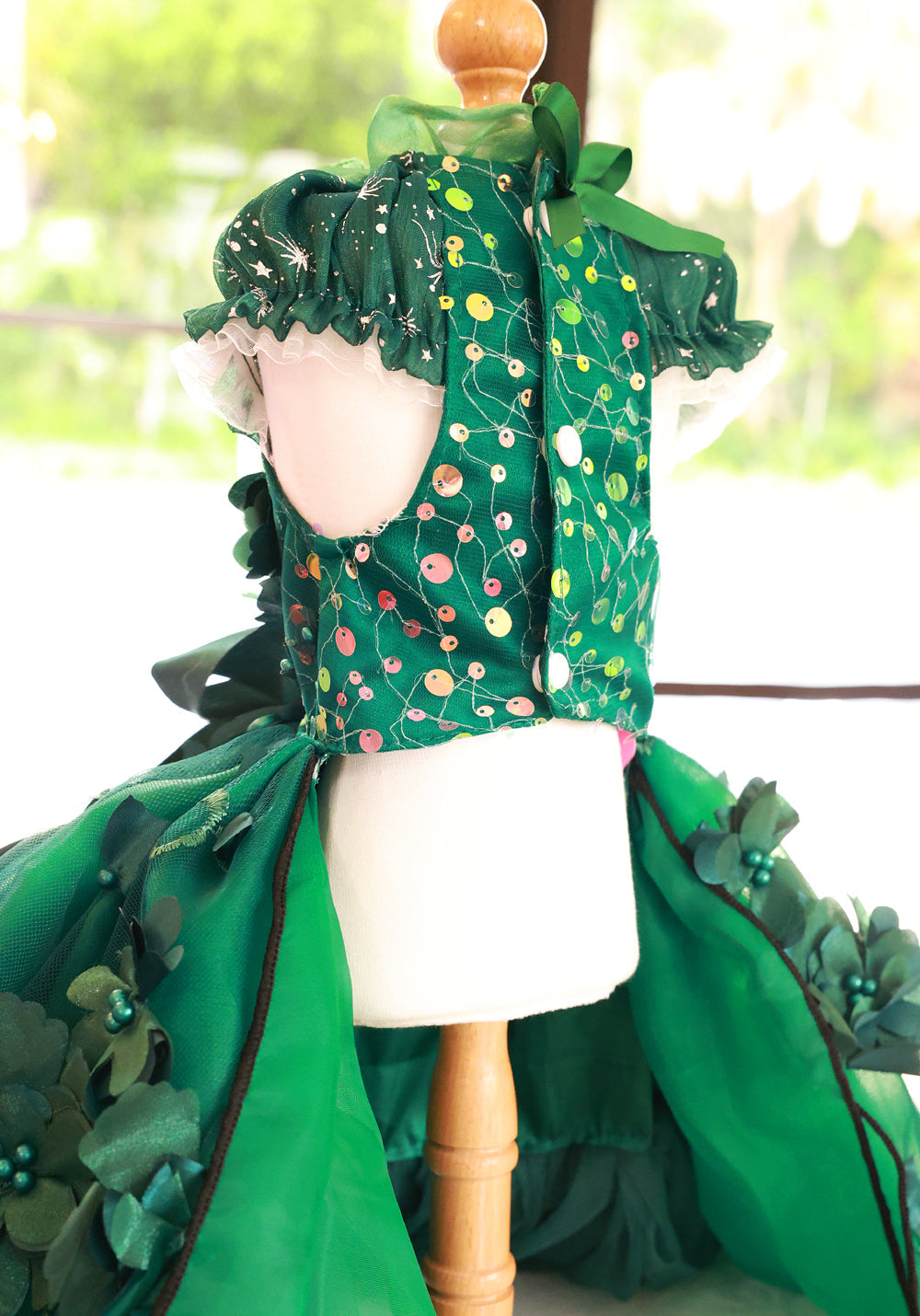 Green floral dress on a mannequin with a blurred outdoor background
