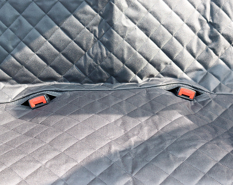 Gray quilted car mat with red clips on a textured surface